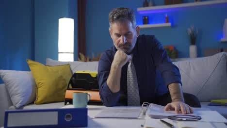 Thoughtful-businessman-looking-at-file-folders-in-his-modern-home-thinking-about-future-corporate-successful-plan-ideas.